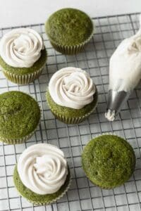 White chocolate frosting piped on matcha green tea cupcakes