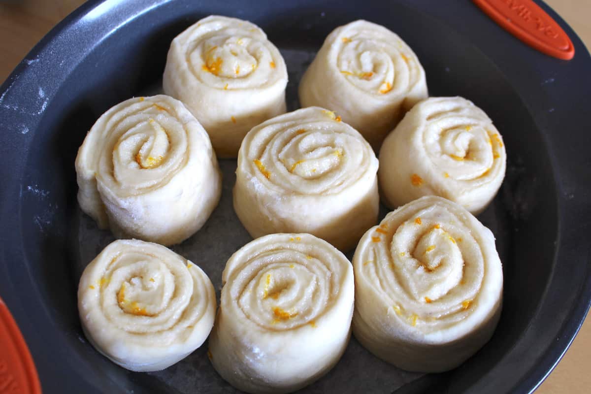 Lemon cinnamon rolls in a round pan before the dough rises.