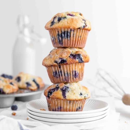 Blueberry muffins stacked on a plate