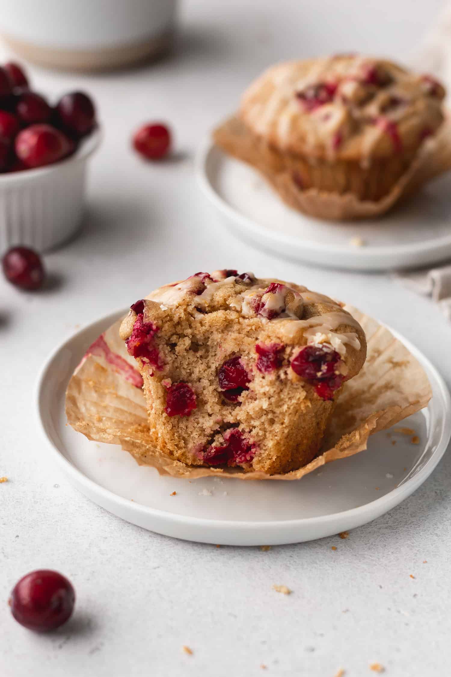Gluten free cranberry muffin on a plate with a bite taken out