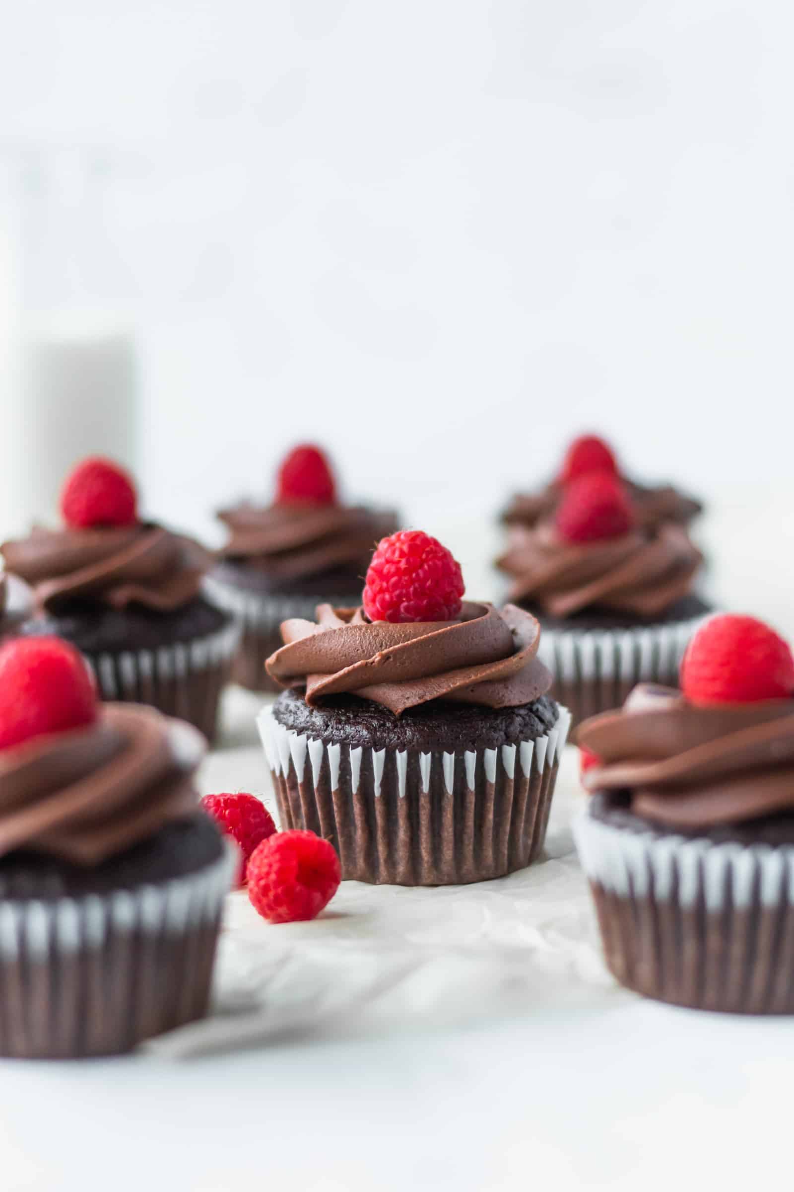 These vegan chocolate banana cupcakes are delicious and moist! Topped with creamy vegan chocolate buttercream and fresh raspberries! #chocolatecupcakes #bananacupcakes #valentinesdaydessert #veganvalentinesday #vegancupcakes
