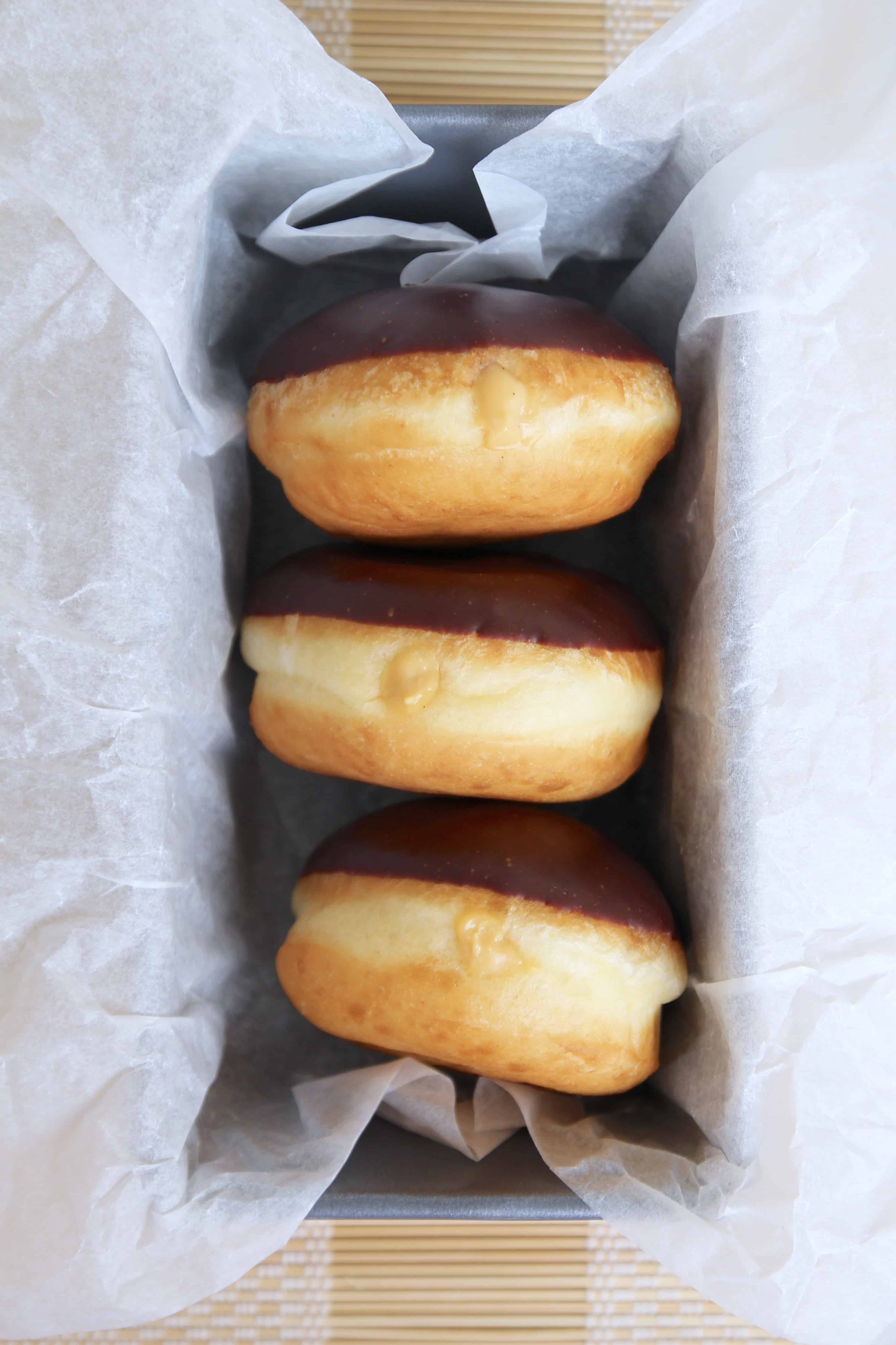Three Boston cream donuts in a loaf pan