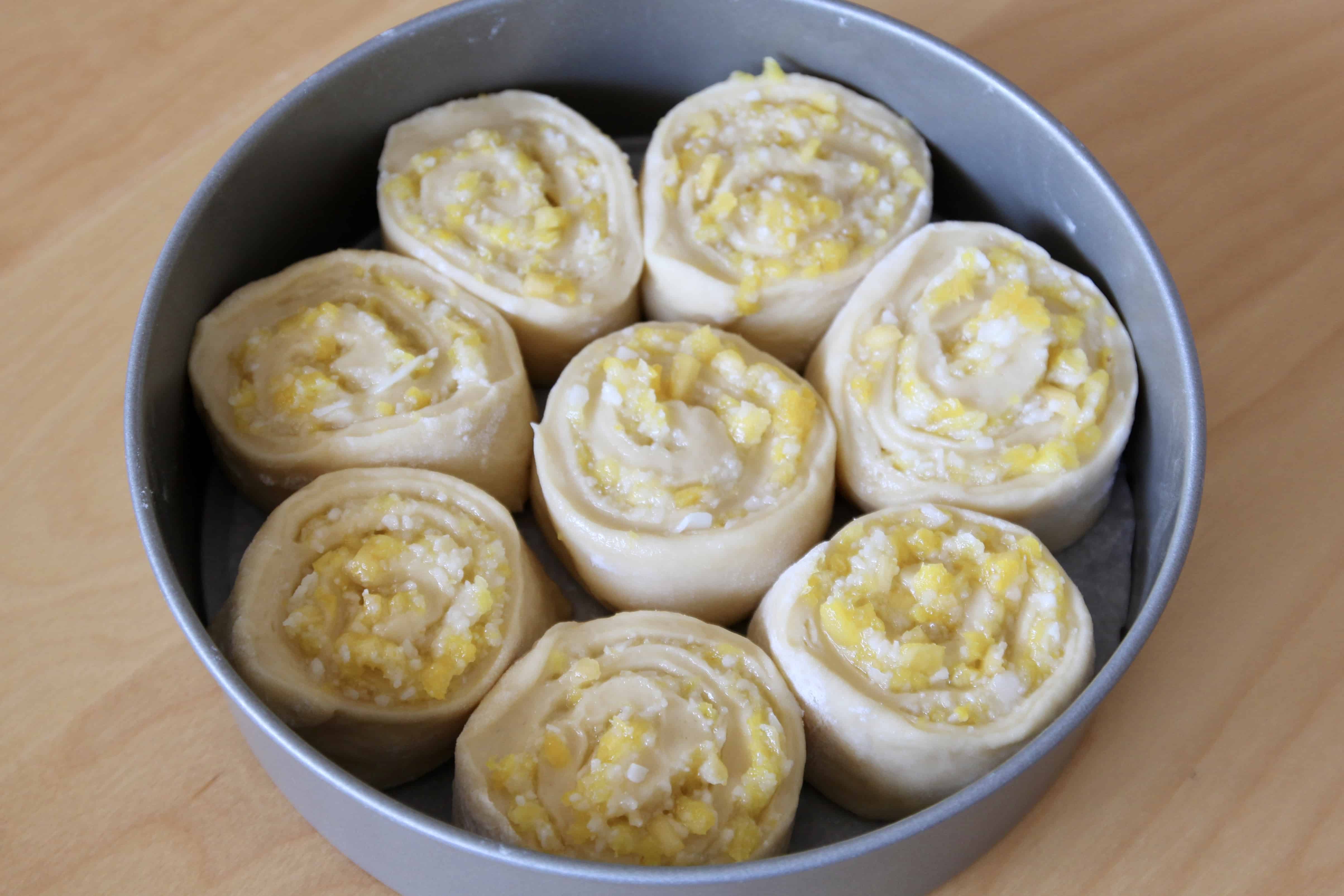 Pineapple and coconut sweet roll dough in a cake pan