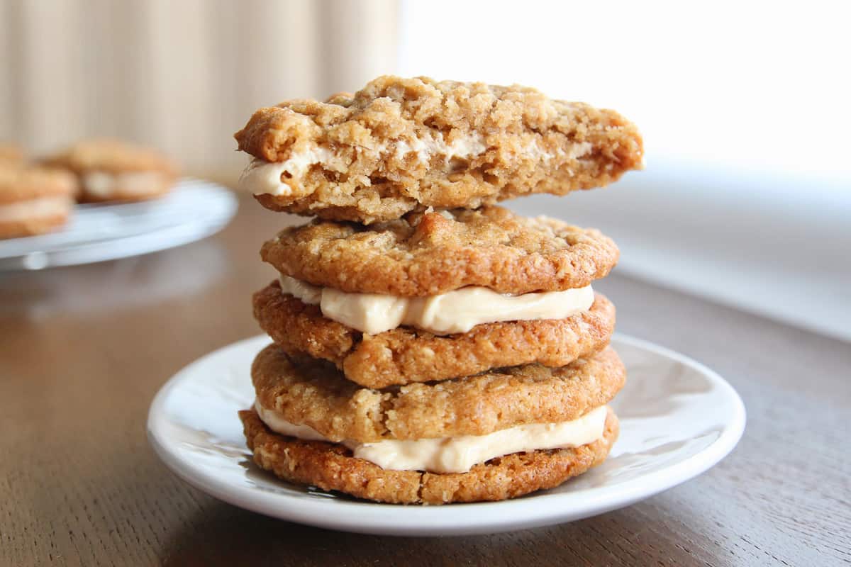 A stack of oatmeal cream pies with a bitten oatmeal cookie sandwich on top.