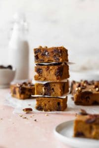 A stack of pumpkin spice blondies with chocolate chips and pecans