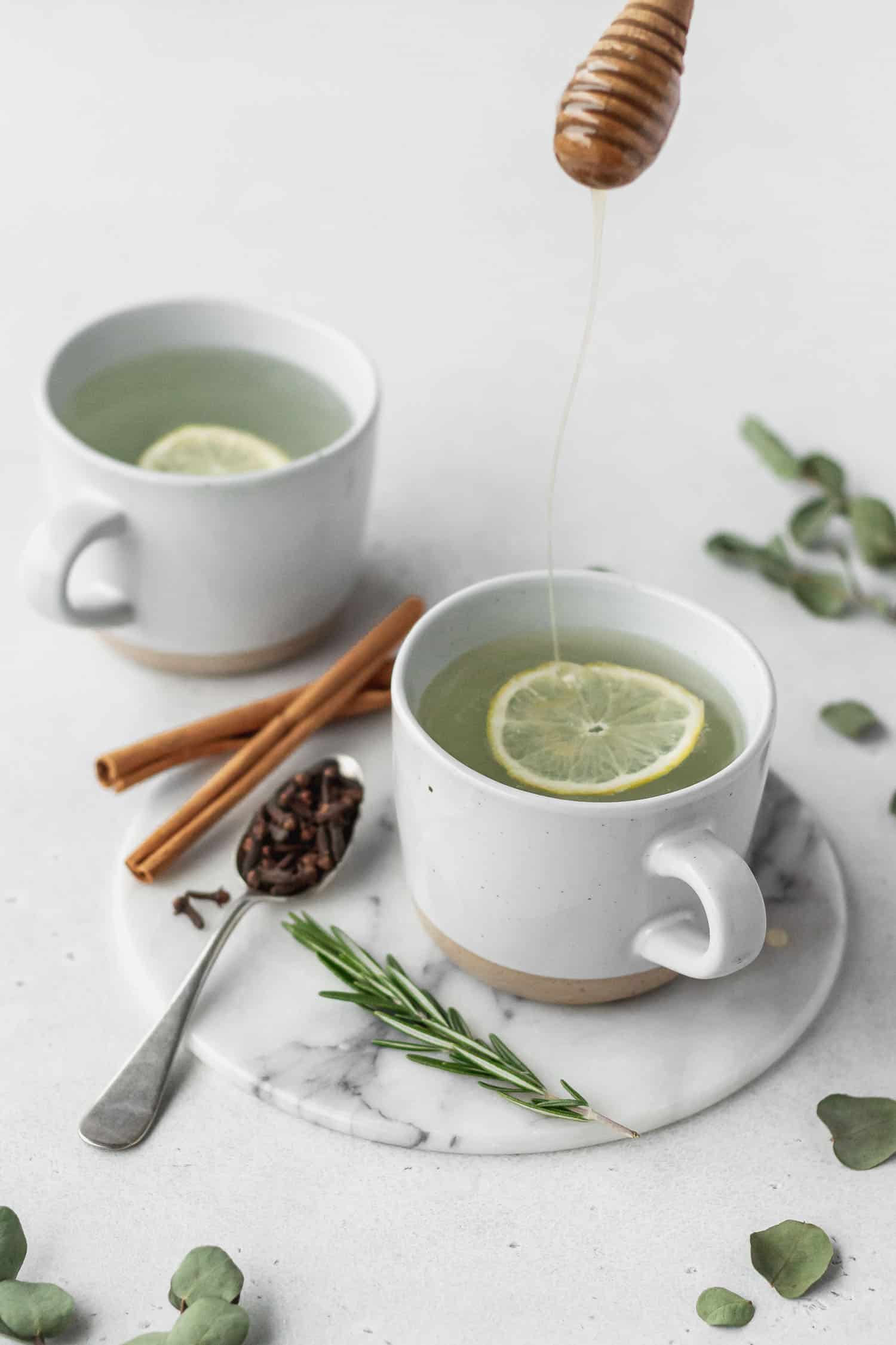Thieves drink with lemon, rosemary, cloves, and cinnamon sticks
