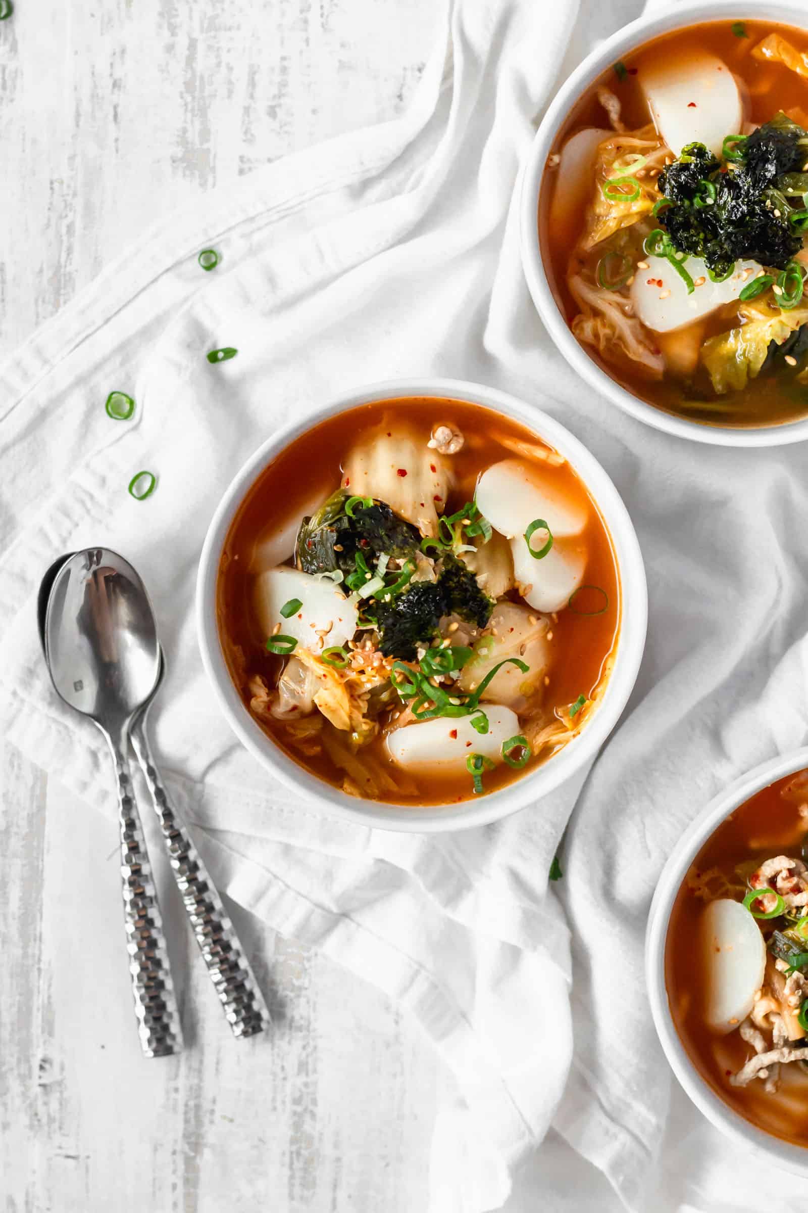 Kimchi tteokguk is a spicy and hearty soup with Korean mochi that'll keep you warm and healthy! The kimchi adds probiotics for a healthy gut! #kimchisoup #probiotics #spicysoup #Koreanfood #healthymeals