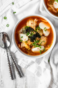 Kimchi tteokguk is a spicy and hearty soup with Korean mochi that'll keep you warm and healthy! The kimchi adds probiotics for a healthy gut! #kimchisoup #probiotics #spicysoup #Koreanfood #healthymeals