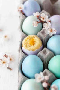 Dyed eggs in a carton with vanilla cake baked in an eggshell