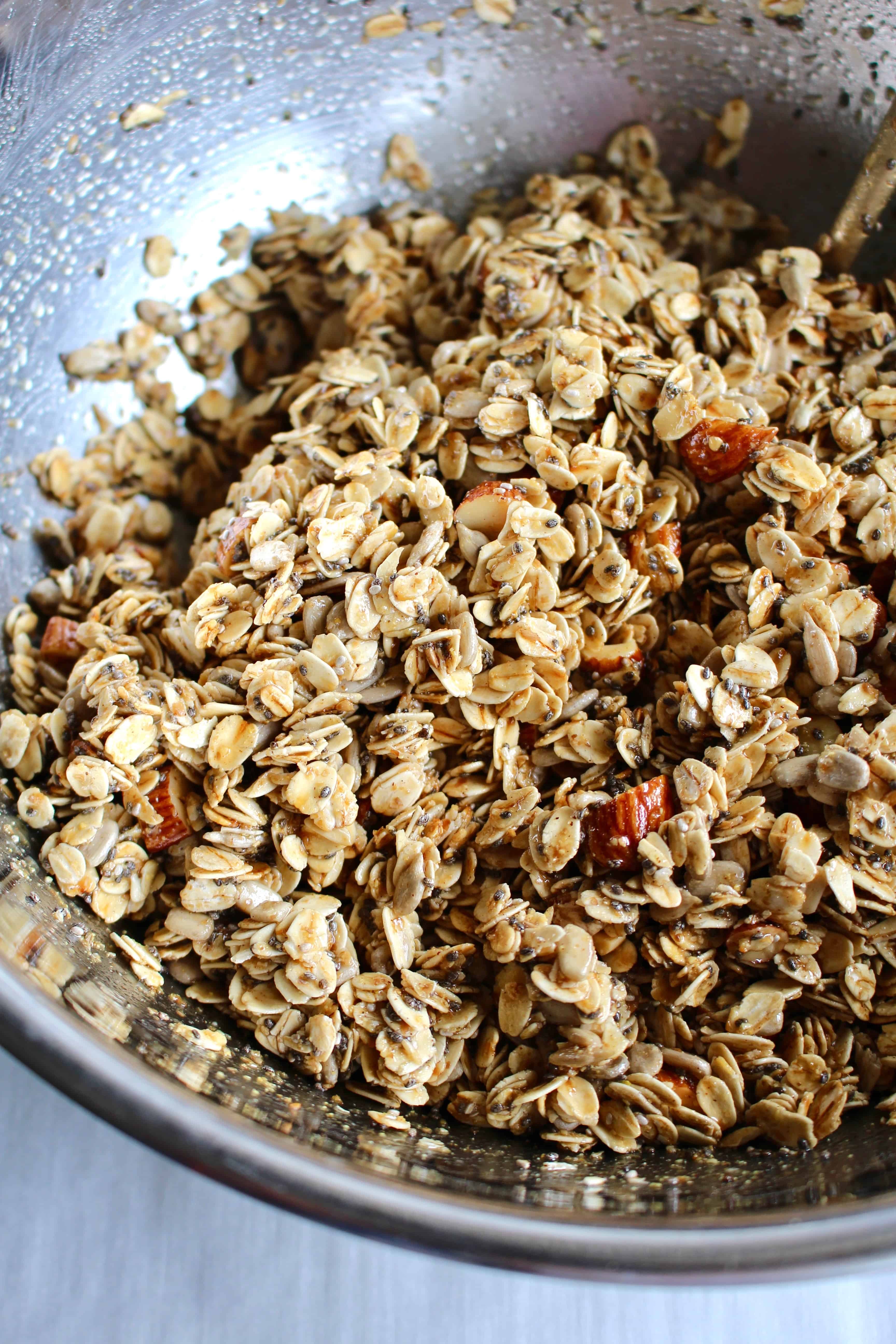 Gluten-free granola ingredients mixed in a metal bowl.
