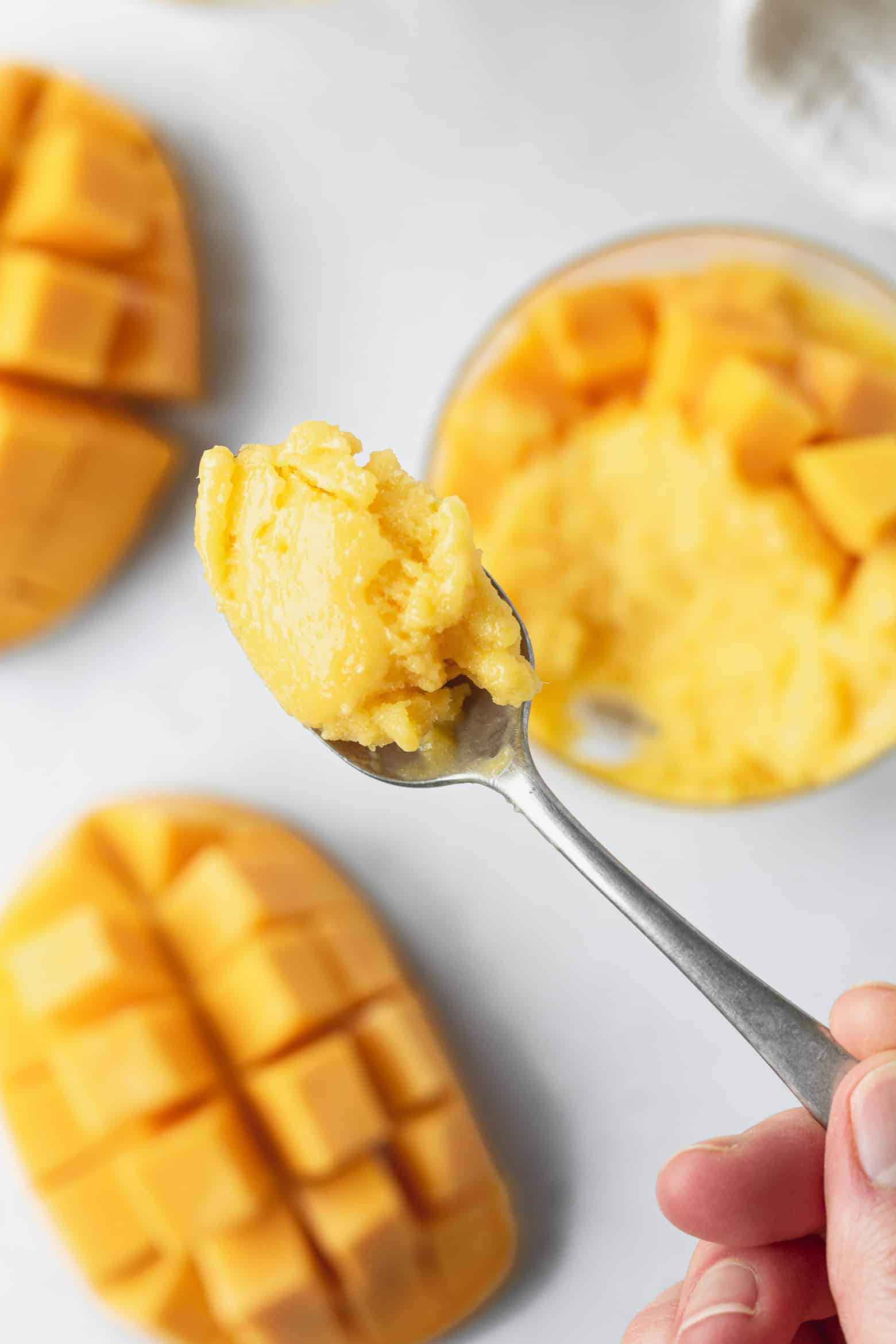 A bite of mango ice cream on a spoon