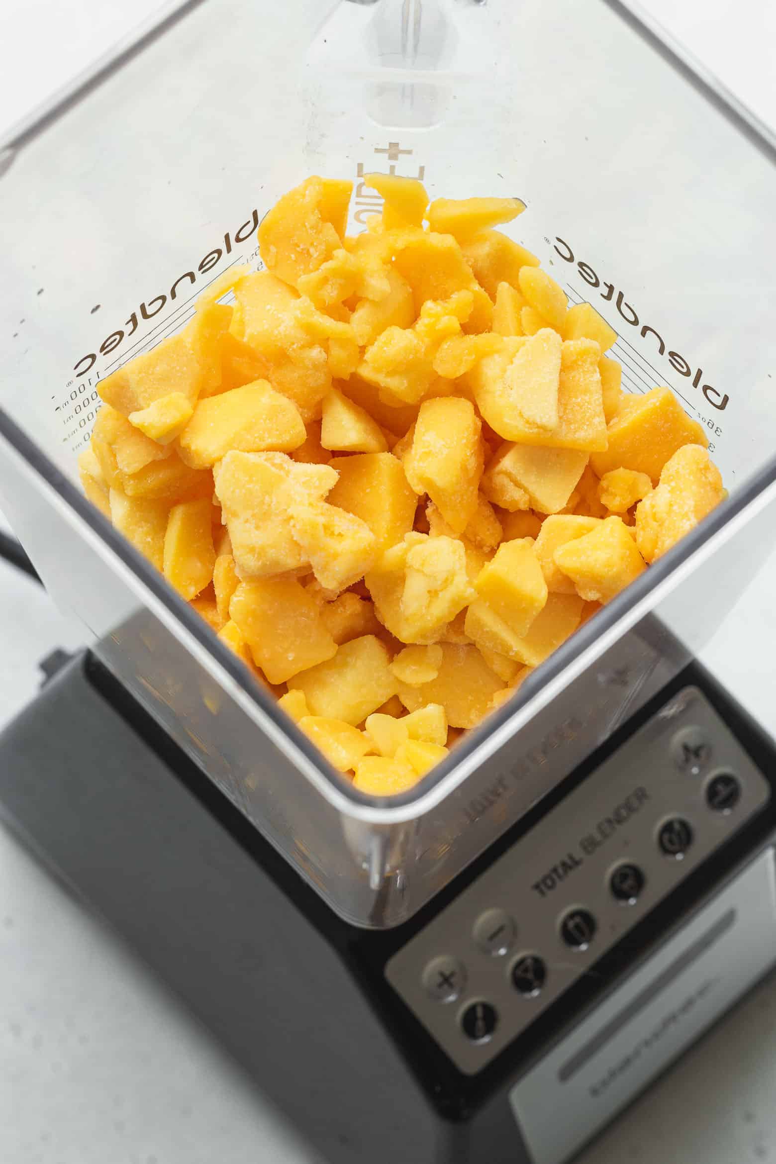 Frozen mango cubes in a blender