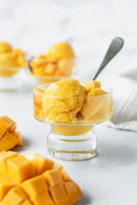 Scoops of mango lime sorbet in a glass