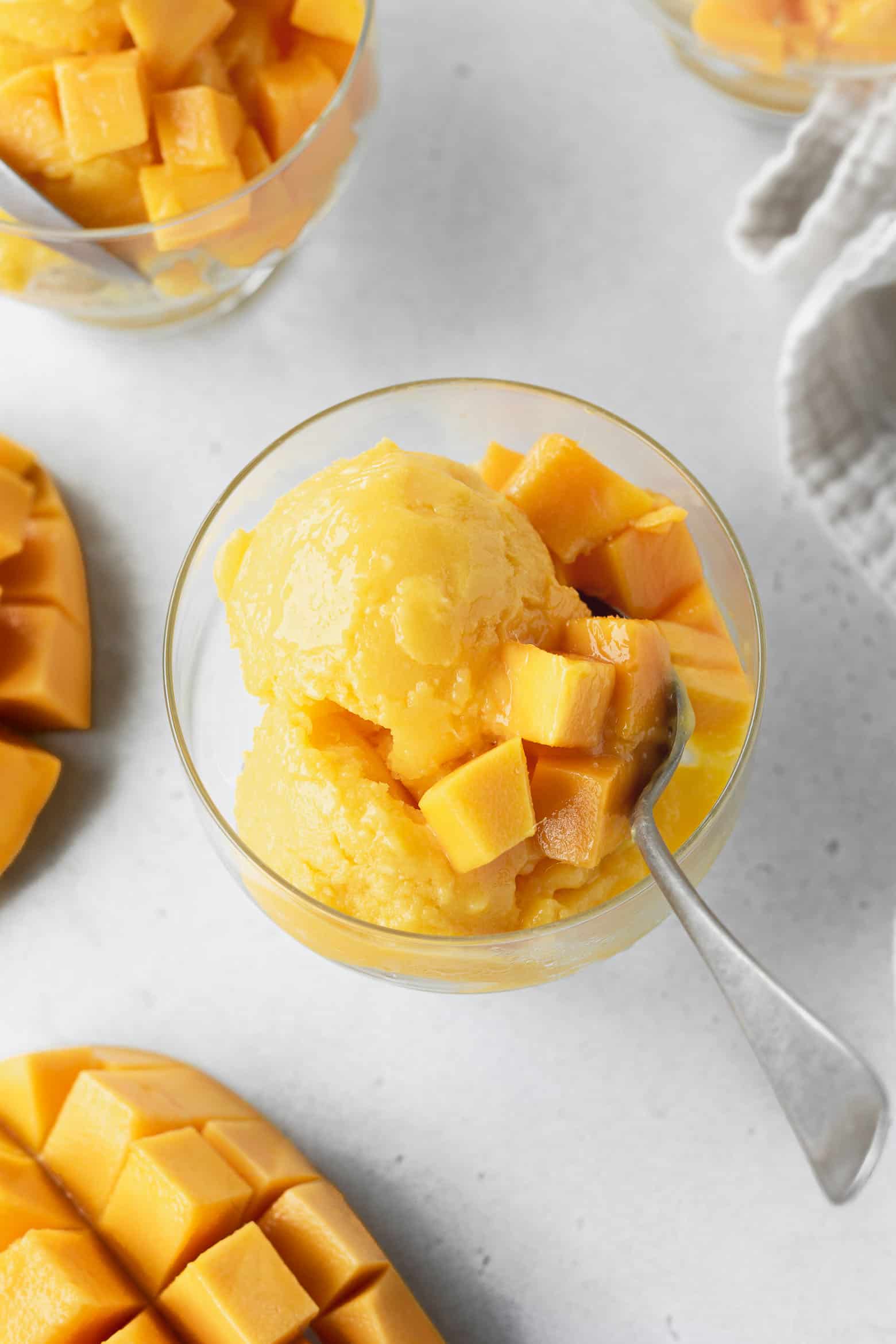 Mango sorbetto in a glass with mango chunks