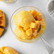Scoops of mango lime sorbet in a glass