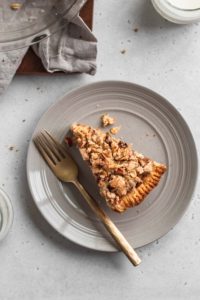 A slice of gluten free apple crumble pie on a plate