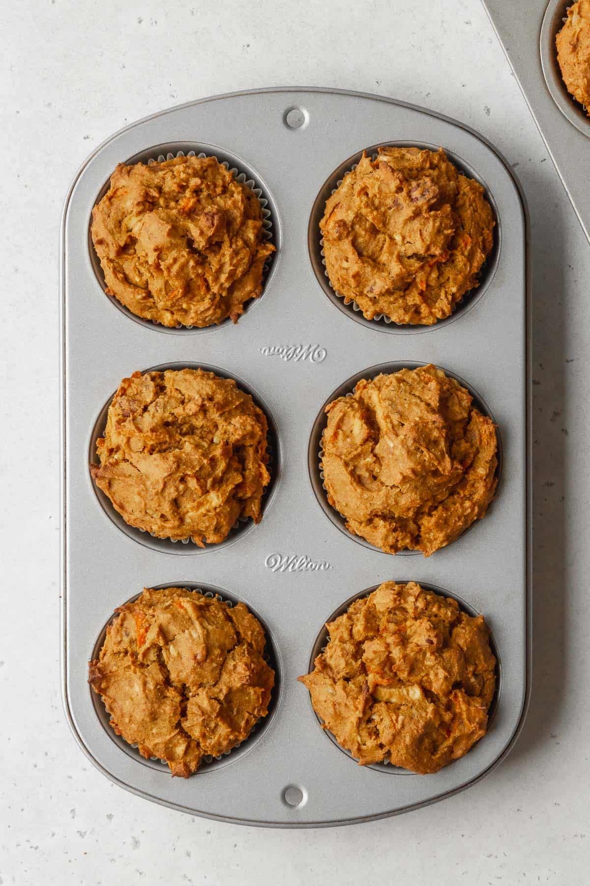 Process shot - pumpkin morning glory muffins cooling in the tin after baking.
