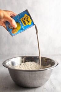 Pouring a can of coconut milk into a bowl
