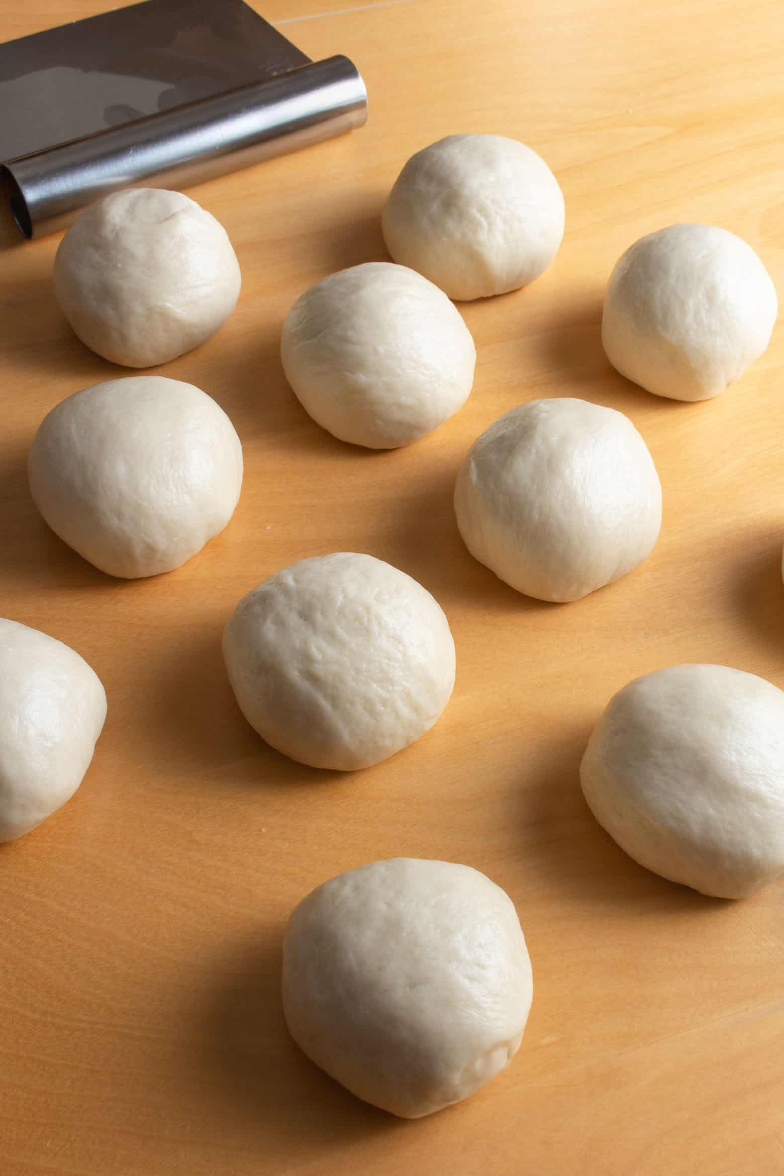 Balls of bread dough on a wooden table.