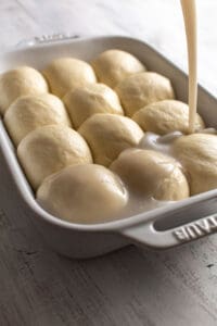 Coconut sauce being poured over dough