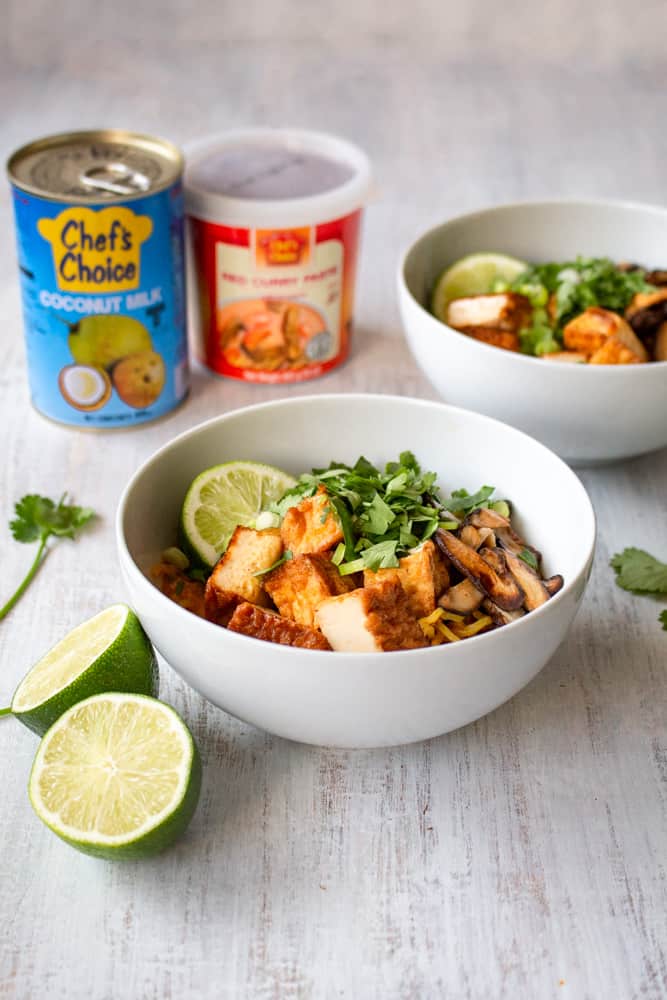 This vegan Thai red curry ramen is your new go-to quick and easy comfort food! Red curry paste and coconut milk make the perfect spicy and creamy soup for ramen noodles, deep fried tofu, and sautéed shiitake mushrooms. The scallions, cilantro, and lime juice tie it all together in this vegan fusion deliciousness! #veganrecipe #veganramen #thairedcurry #currypaste #coconutmilk