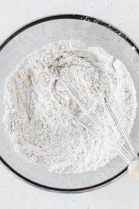 A bowl of flour and a whisk