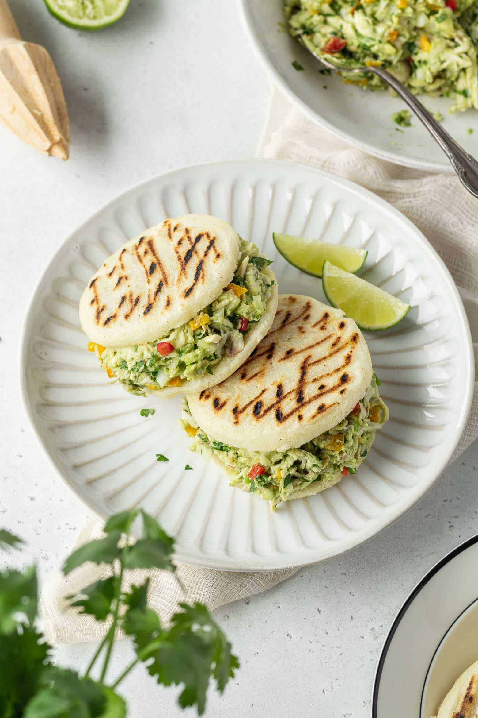 Two reina pepiada on a plate with lime wedges