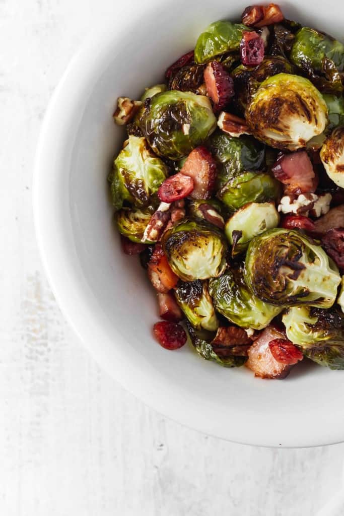 Brussels sprouts that don't suck and are actually delicious! Brussels sprouts are roasted with bacon, dried cranberries, and pecans. #roastedbrusselssprouts #brusselssprouts #thanksgivingsidedish #thanksgivingdinner #sprouts