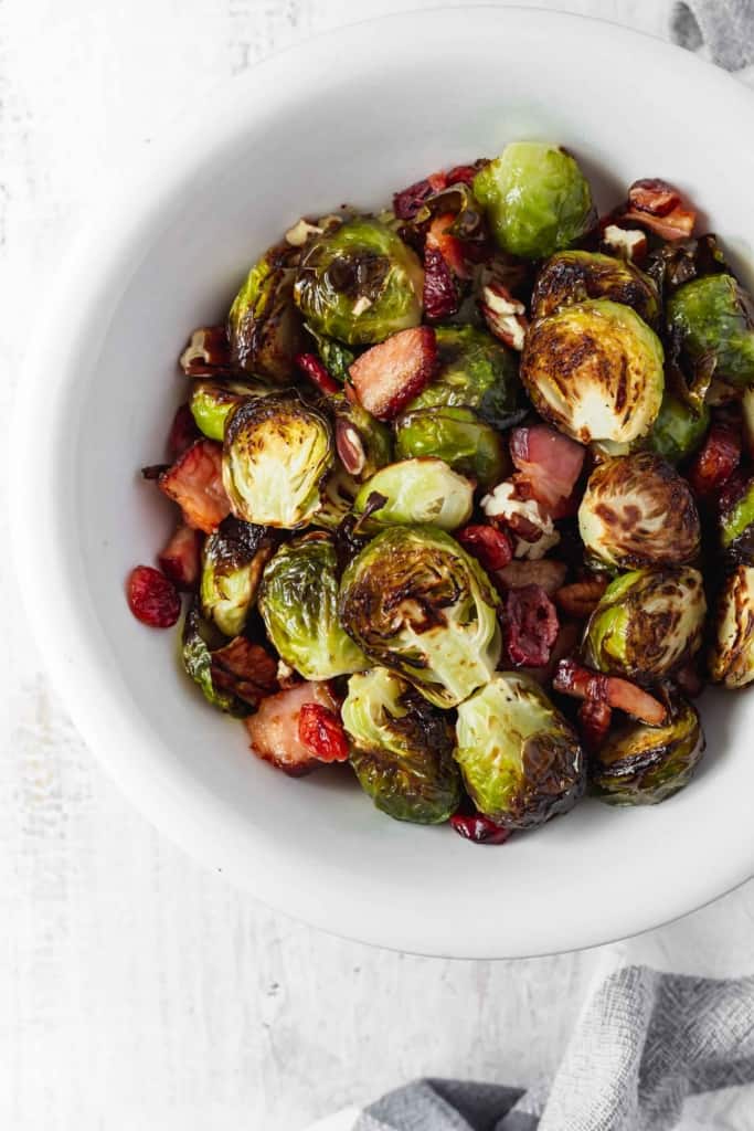 Brussels sprouts that don't suck and are actually delicious! Brussels sprouts are roasted with bacon, dried cranberries, and pecans. #roastedbrusselssprouts #brusselssprouts #thanksgivingsidedish #thanksgivingdinner #sprouts