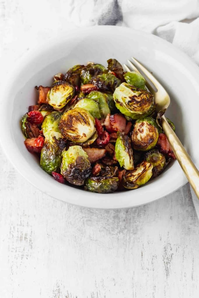 Brussels sprouts that don't suck and are actually delicious! Brussels sprouts are roasted with bacon, dried cranberries, and pecans. #roastedbrusselssprouts #brusselssprouts #thanksgivingsidedish #thanksgivingdinner #sprouts