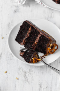 A slice of moist and fluffy chocolate cake on a white plate