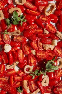 Close up of cherry tomatoes, vegan calamari, garlic, and fresh oregano