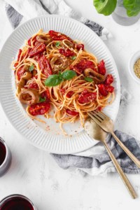 A plate of spaghetti with cherry tomato sauce