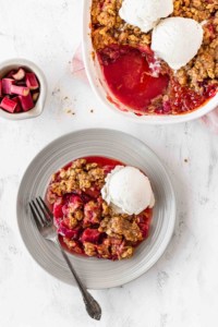 Rhubarb crisp on a plate with a scoop of ice cream