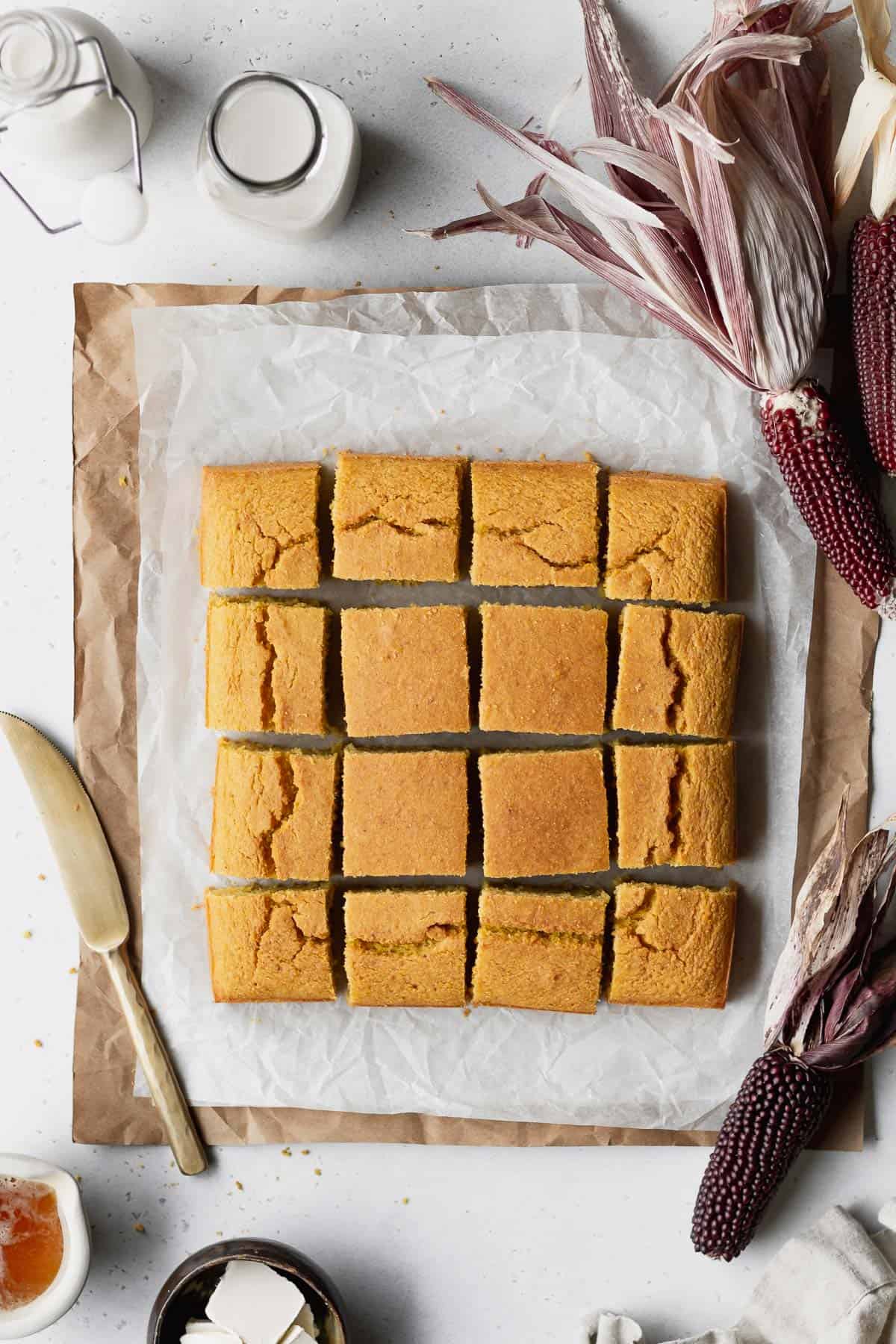 Overhead shot of a square of gluten-free dairy-free cornbread cut into 16 squares.