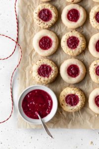 Gluten free and dairy free thumbprint cookies with a bowl of cranberry sauce