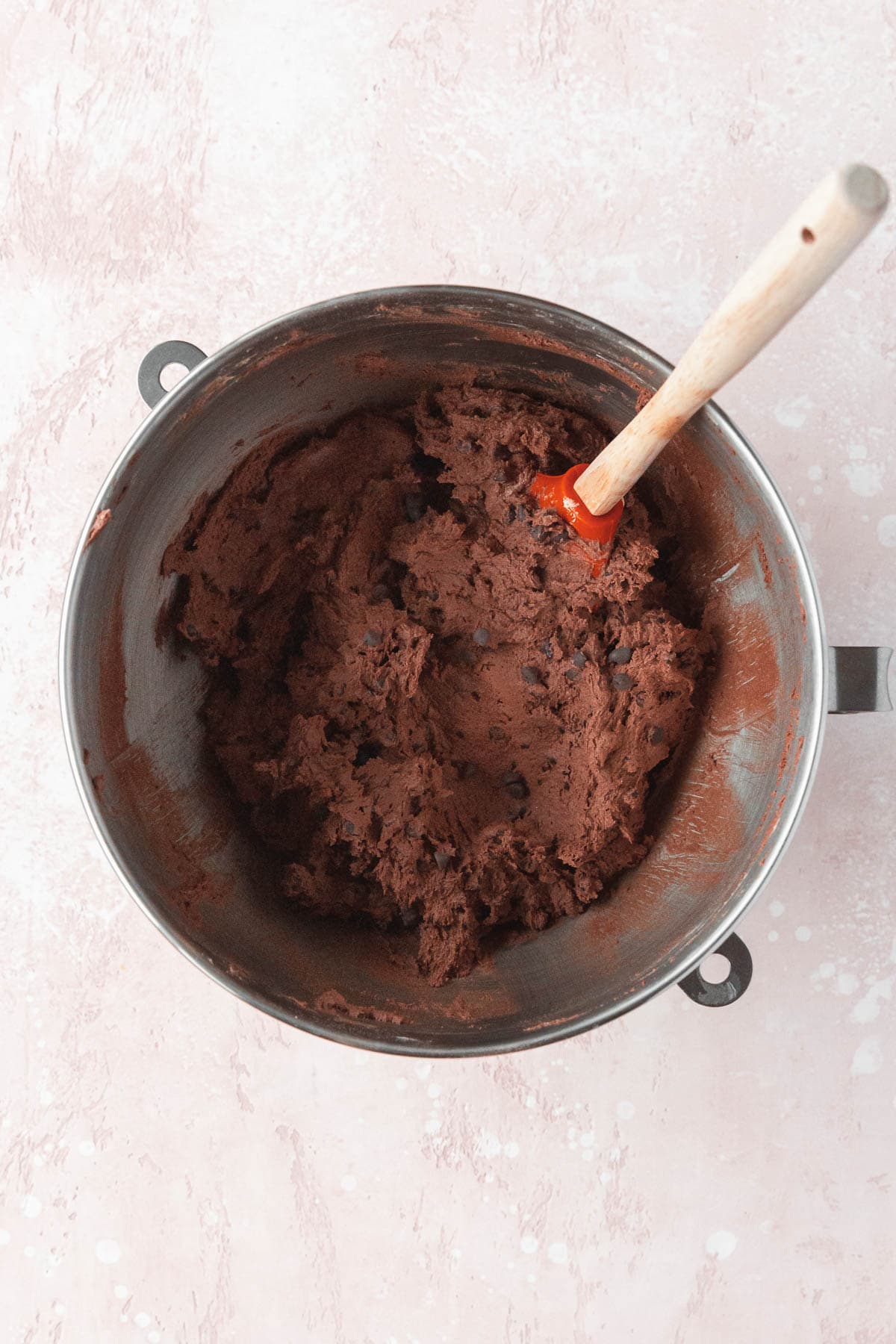 Chocolate chips mixed into the chocolate cookie dough with a spatula.
