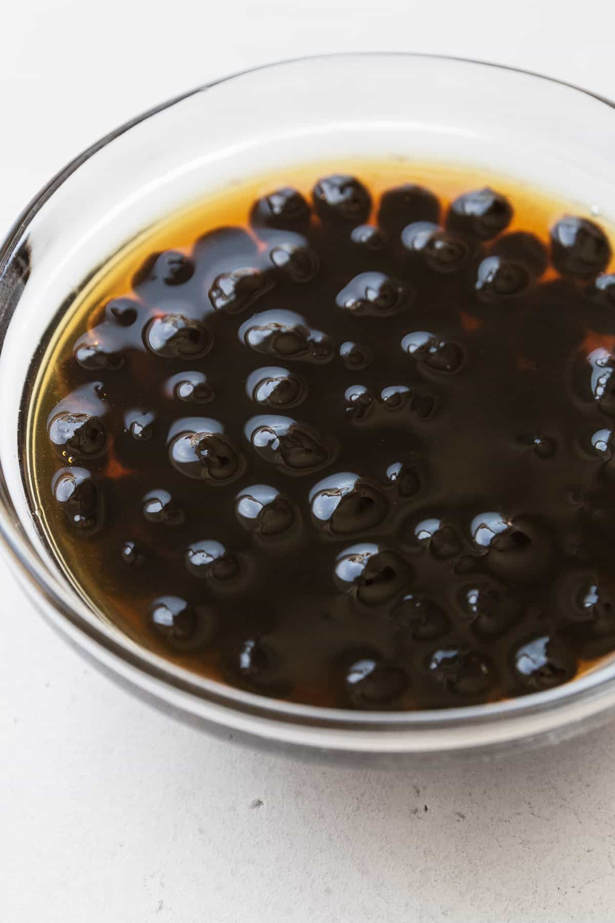 Soaking boba pearls in a small bowl of brown sugar simple syrup. 
