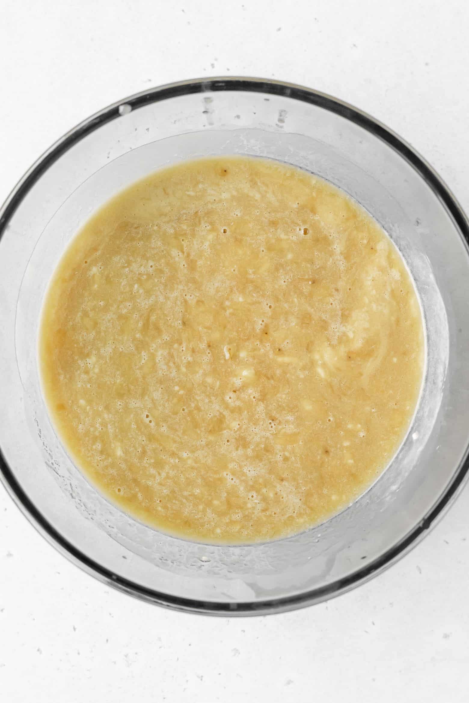 A bowl of wet ingredients for banana bread