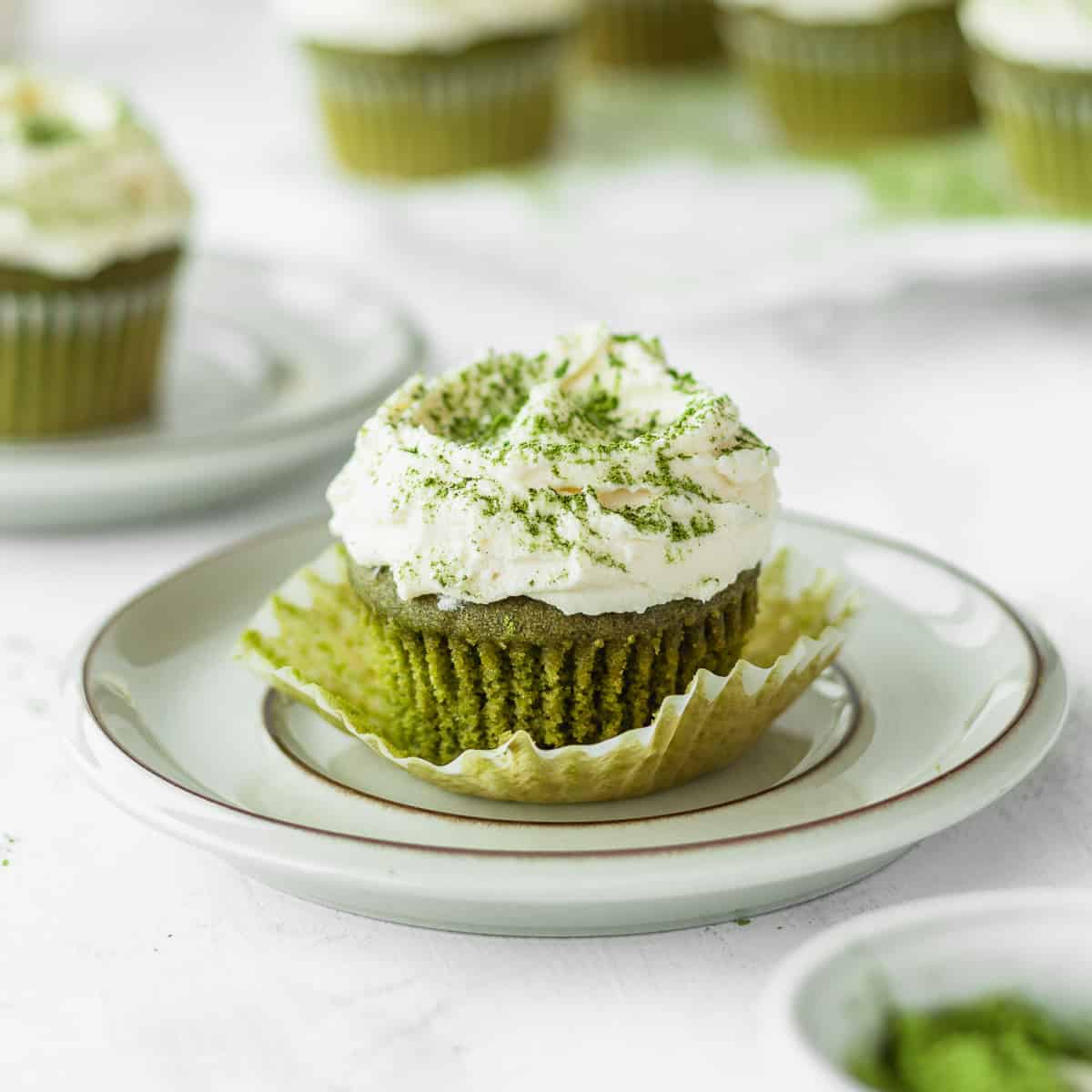 Matcha cupcake with white chocolate frosting on a plate