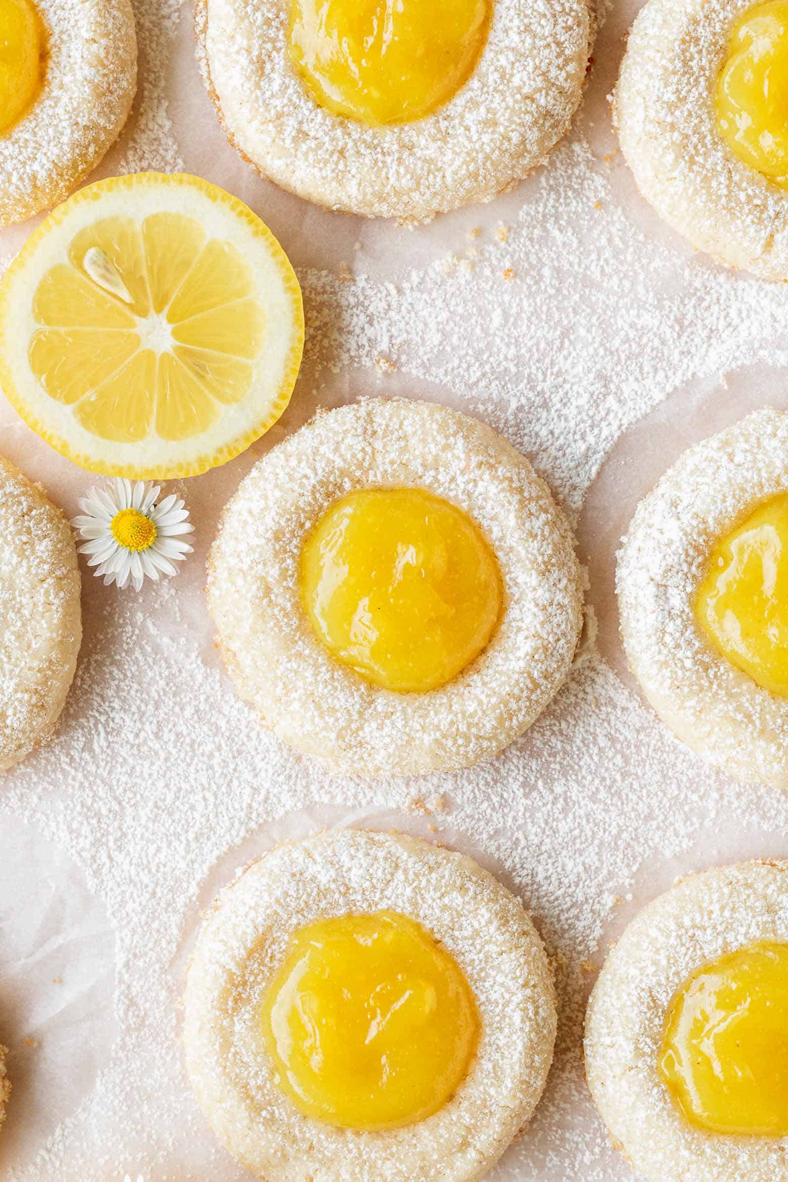 Overhead shot of vegan lemon thumbprint cookies dusted with powdered sugar.