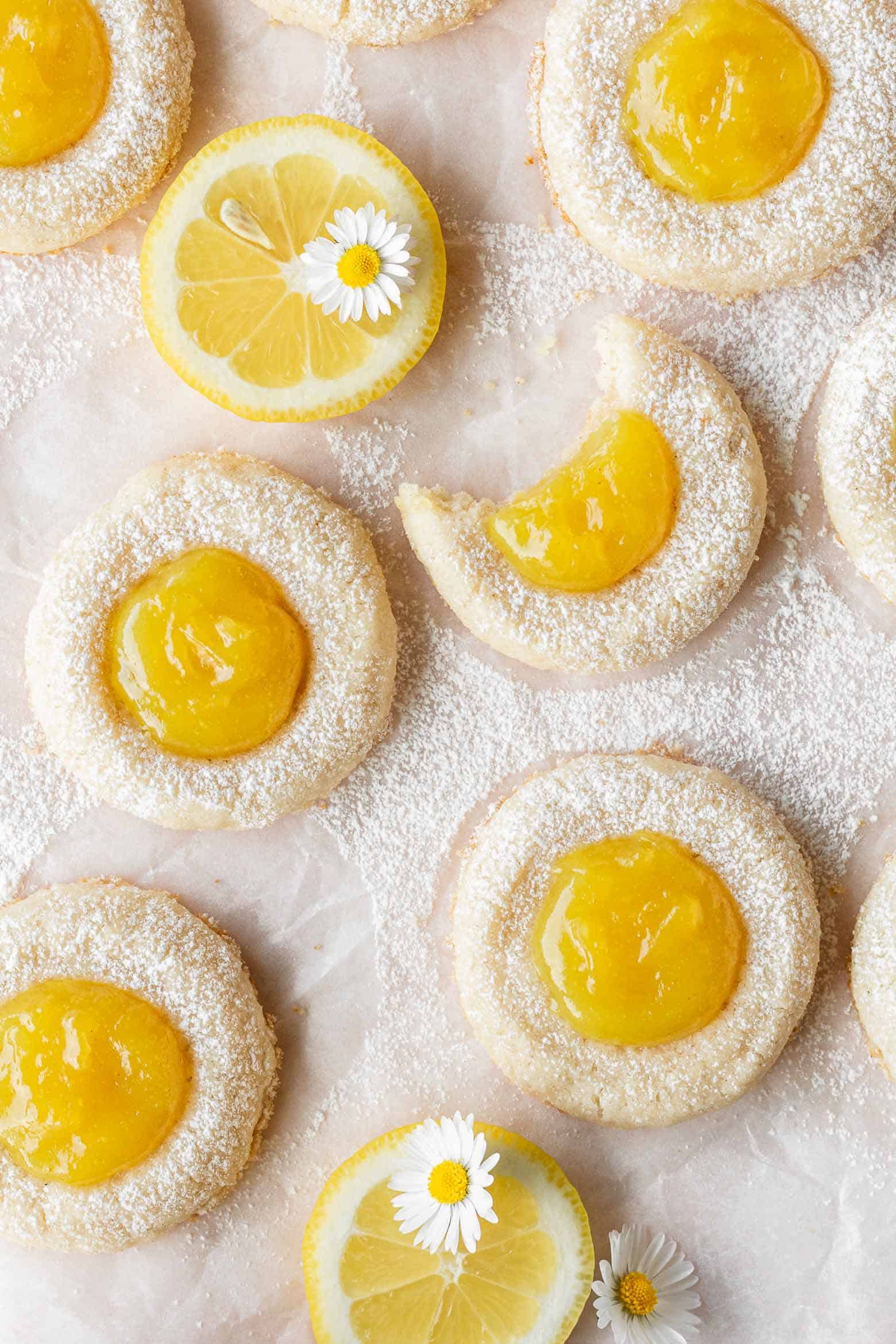 Lemon thumbprint cookies with a bite taken out of one coookie.