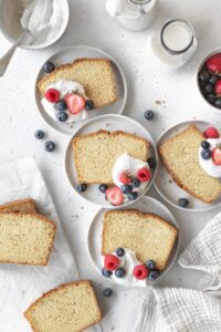 Slices of gluten-free pound cake served with whipped coconut cream and fresh berries.