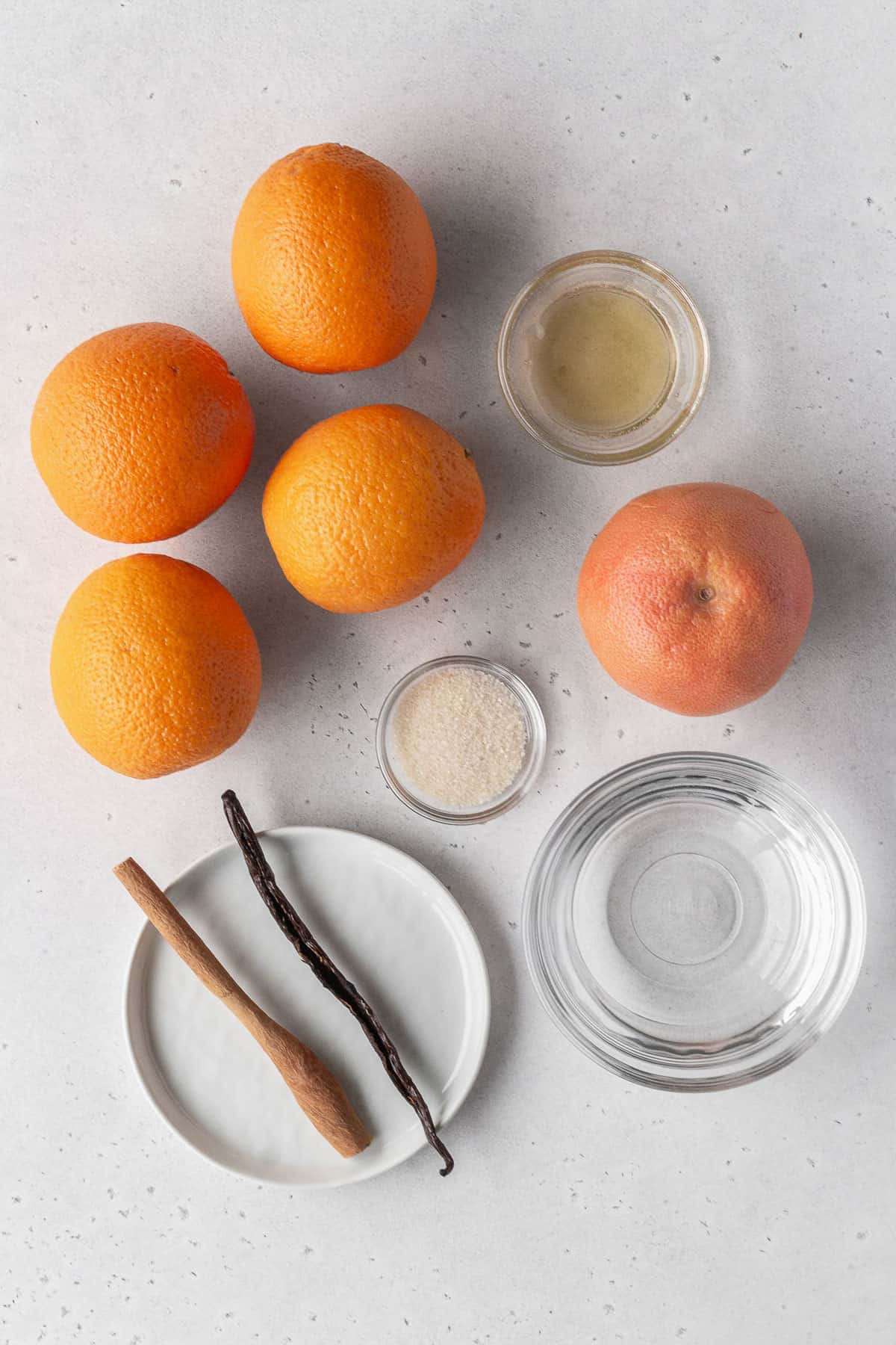 Citrus compote ingredients on a white surface.