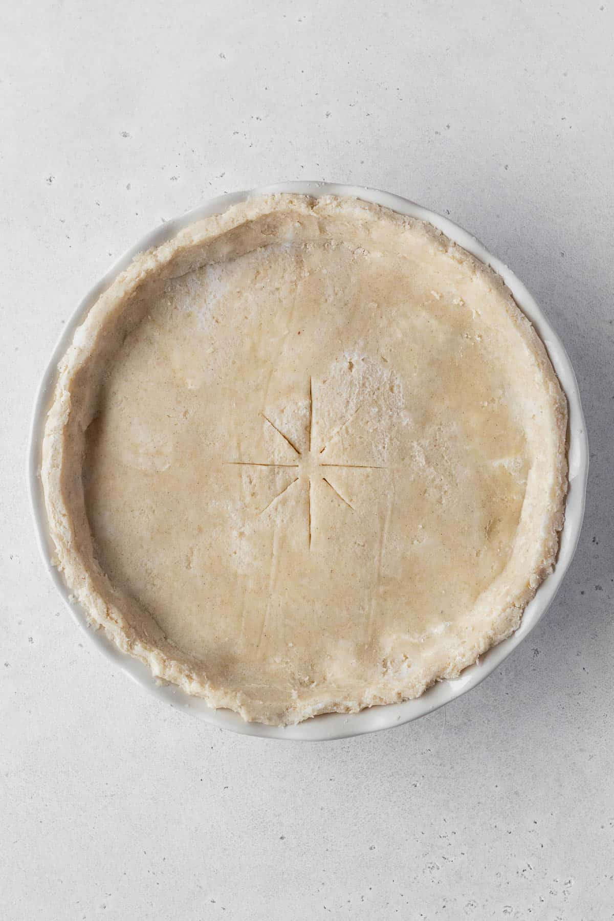 An unbaked pot pie on a grey surface.