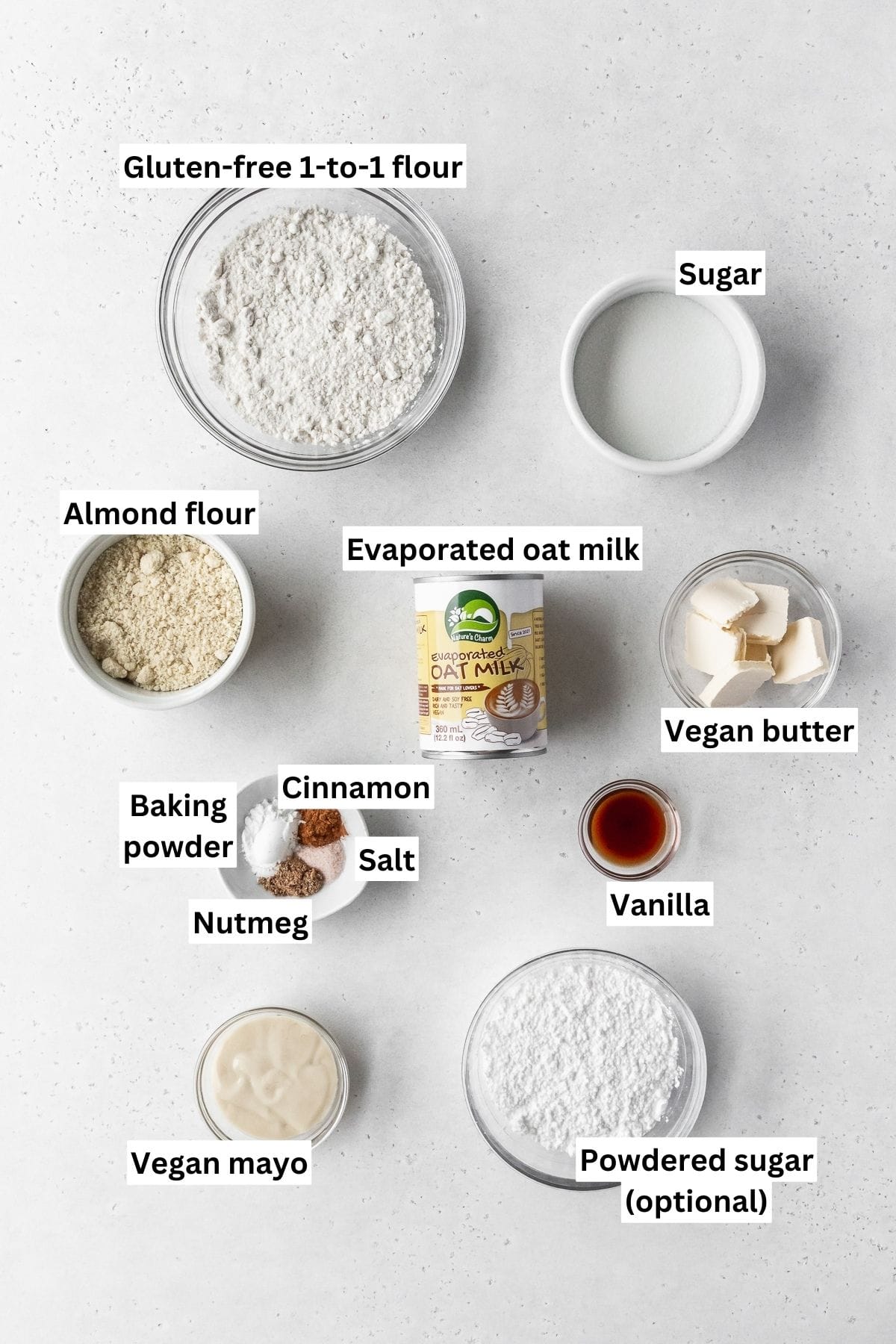 Ingredients needed for making dairy free gluten free vegan baked donuts laid out on a white table with text overlay.