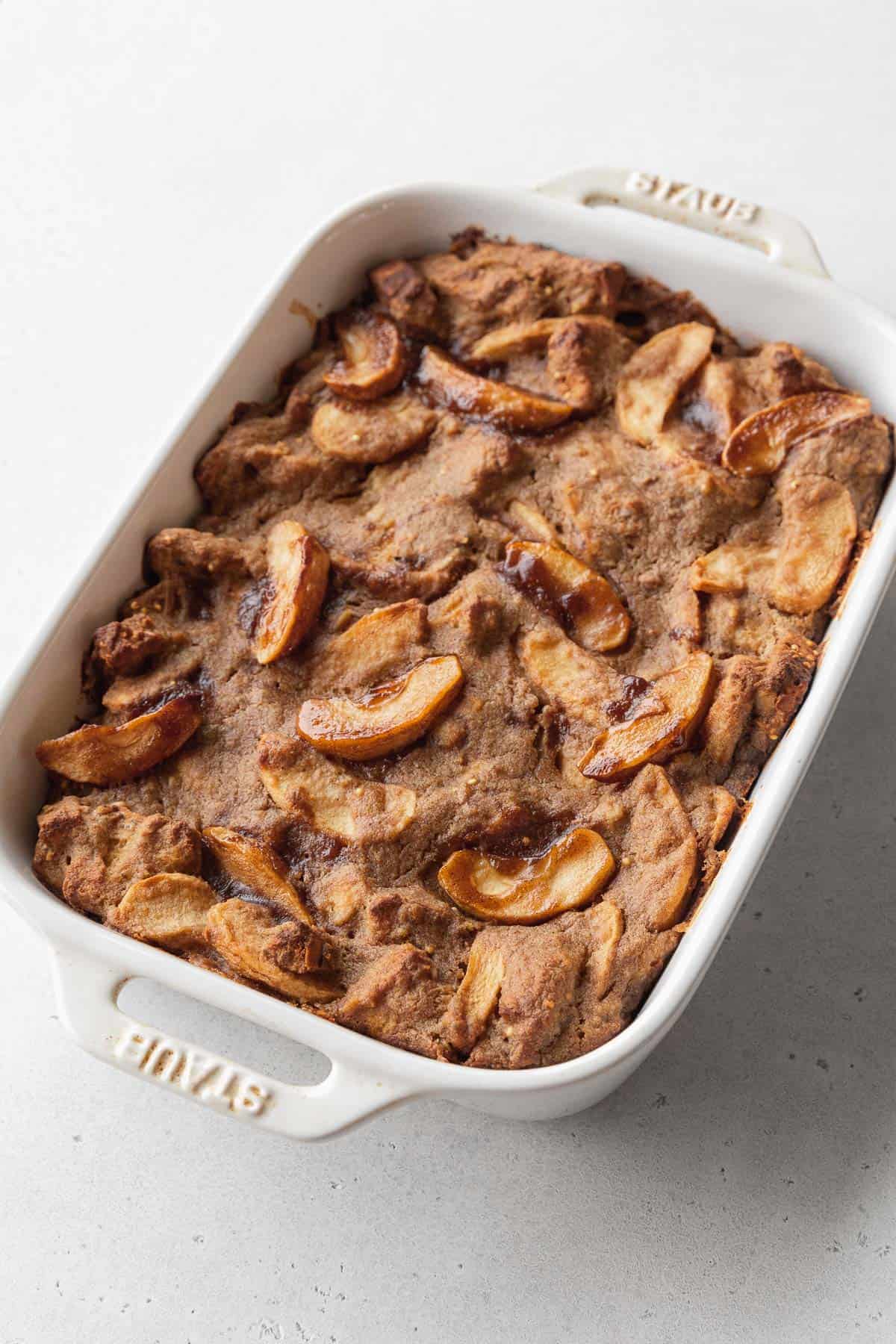 Vegan bread pudding baked in a white casserole dish.