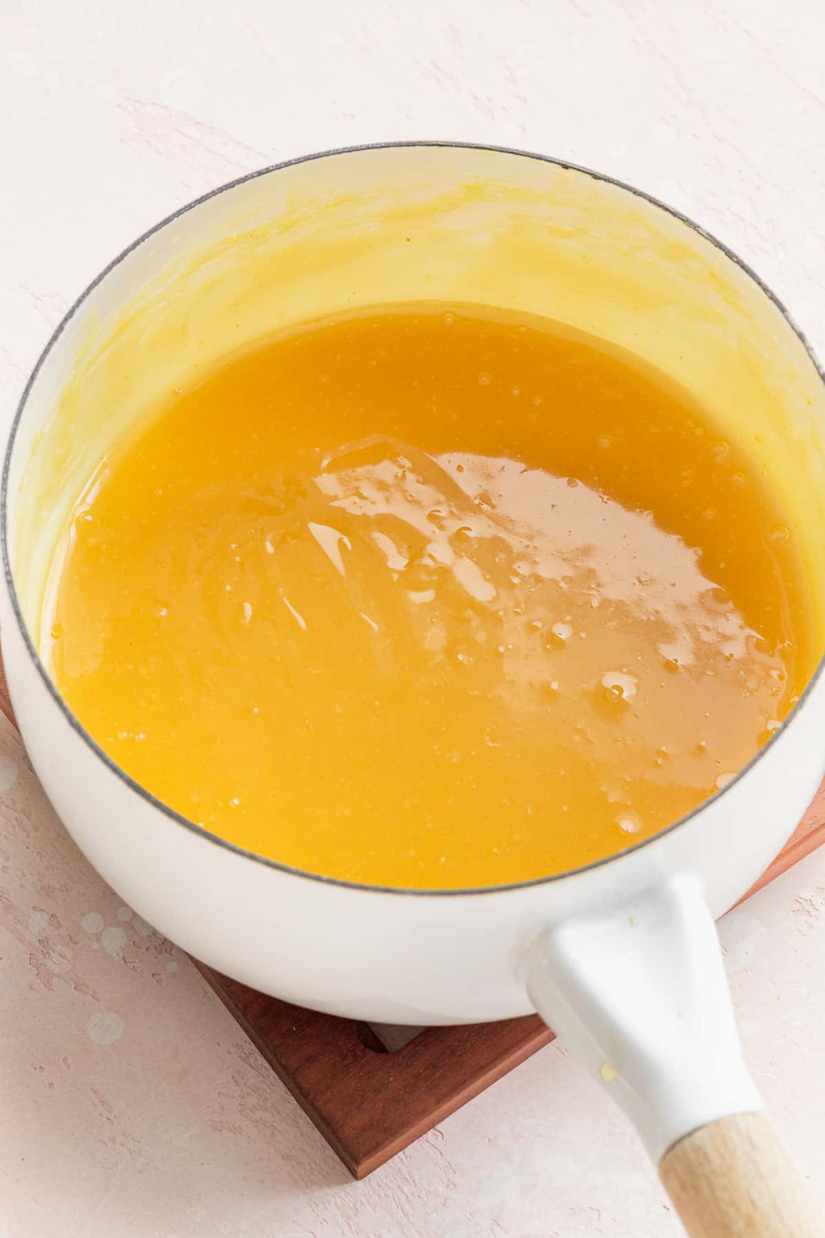 completed lemon curd in a sauce pan. it is bright yellow like the color of an egg yolk.