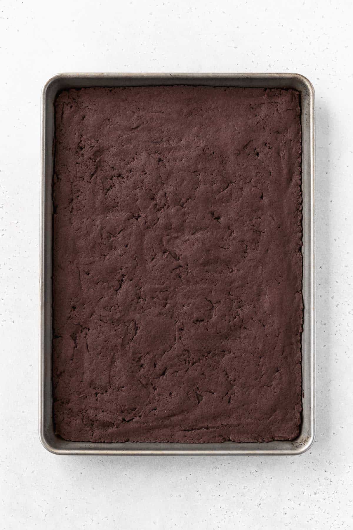Baked chocolate ice cream sandwich cooking on a baking sheet.