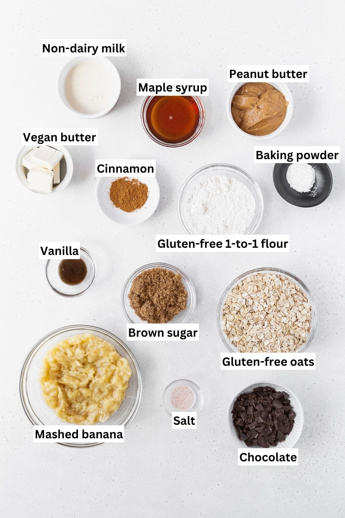 All of the ingredients for peanut butter banana oatmeal bars on a white background.